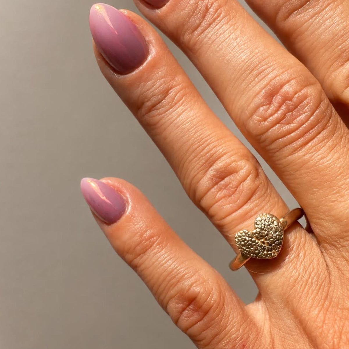 vrouwenhand met ring in brons en een hondenneusafdrukje